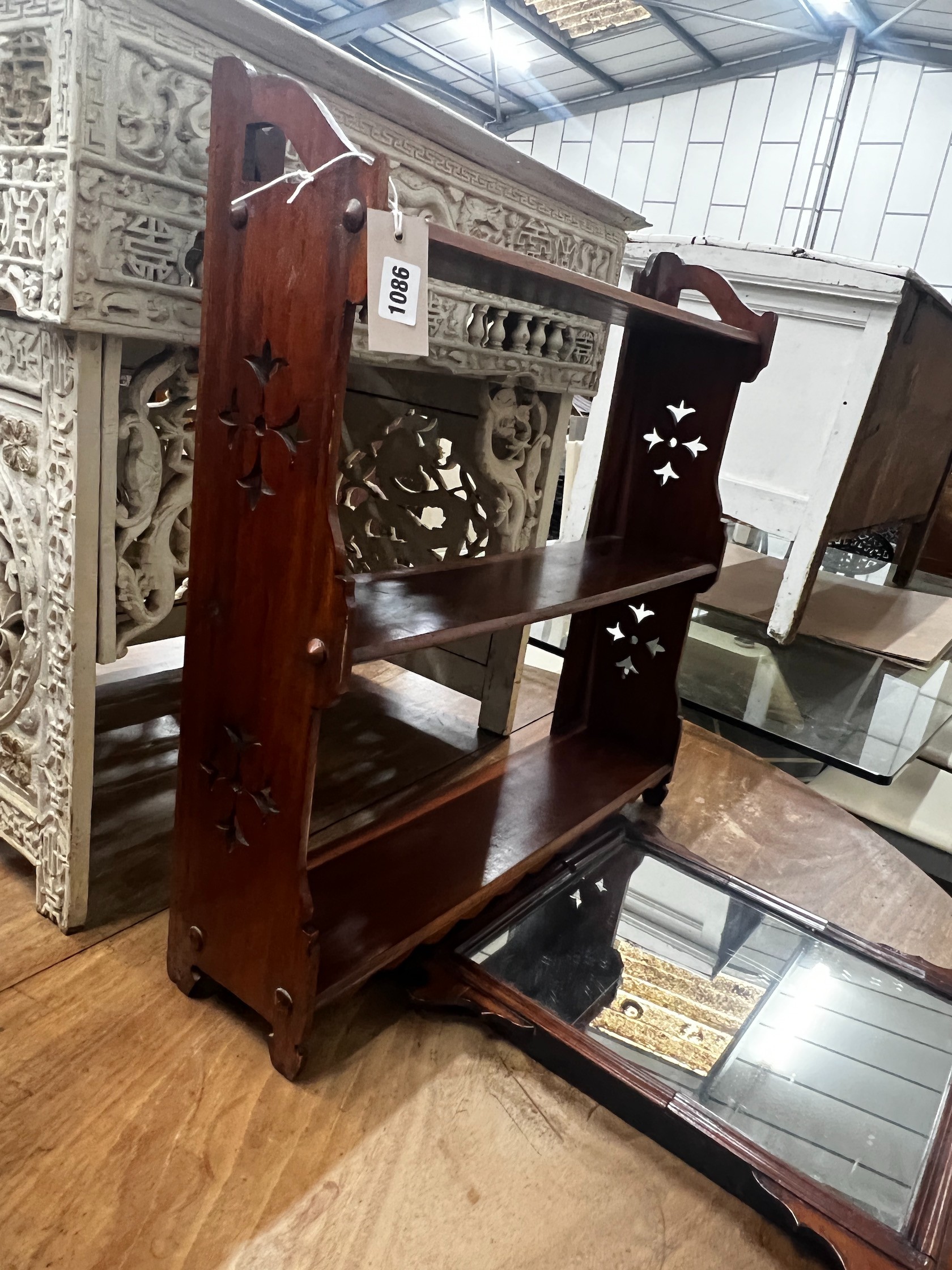A Victorian mahogany three tier wall bracket, width 61cm height 63cm, and a small walnut fret cut wall mirror, height 52cm
